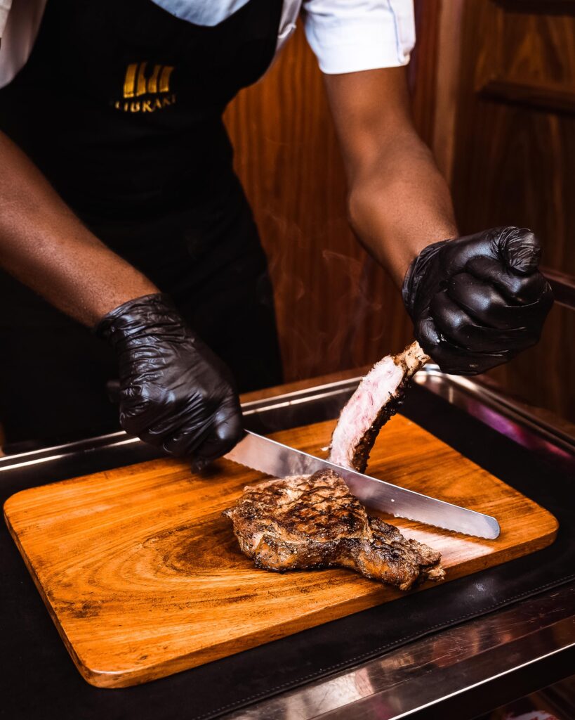 A chef at The Library slicing through a steak