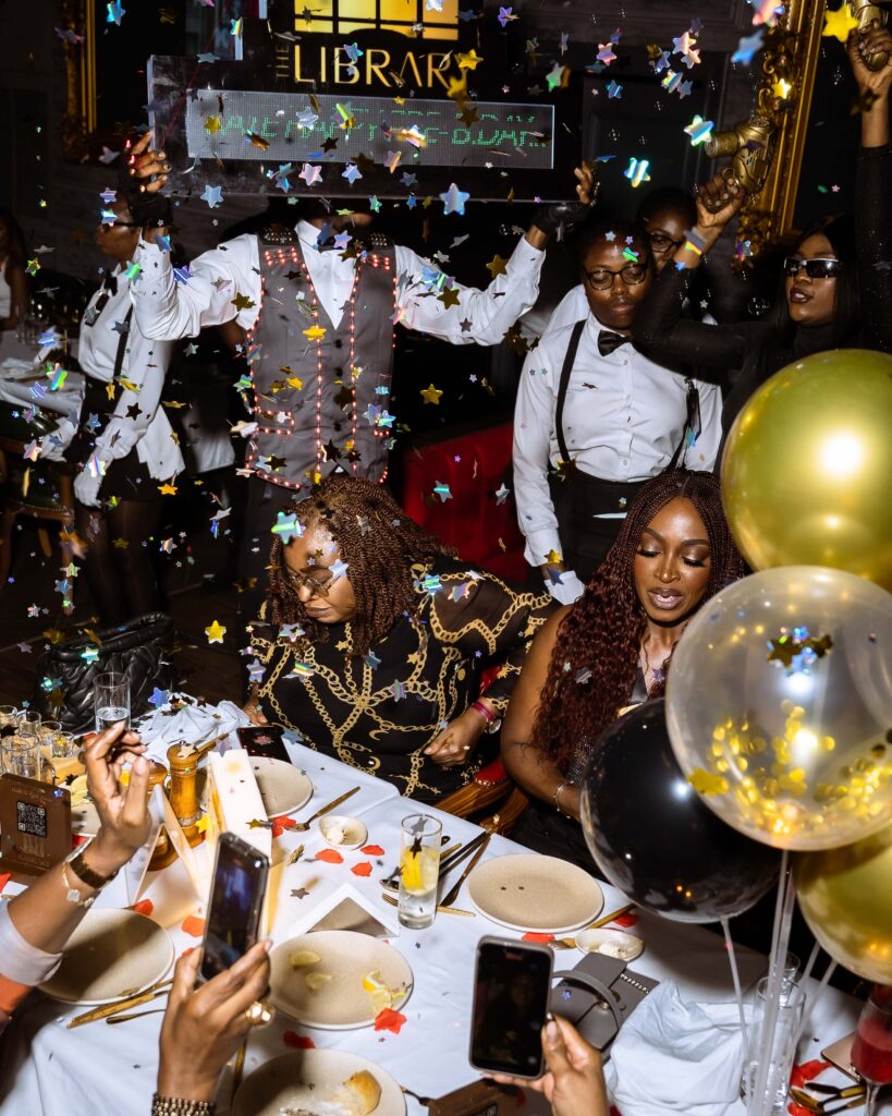 Nigerian celebrity Kate Henshaw celebrating her birthday at The Library Lagos, surrounded by loved ones, balloons, sparkles, and confetti in a lively, elegant setting