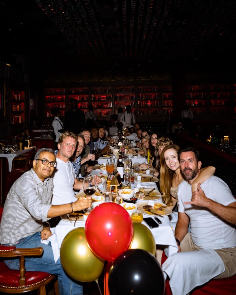 A group of foreign guests at The Library Lagos enjoying a celebratory dinner, wining and dining while watching captivating live performances in the elegant dining space